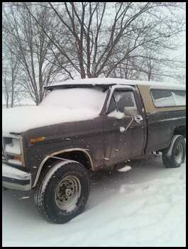 1996 Ford Bronco - Pickup truck with camper shell parked in a snowy field during winter. Supermotors.net logo is present.