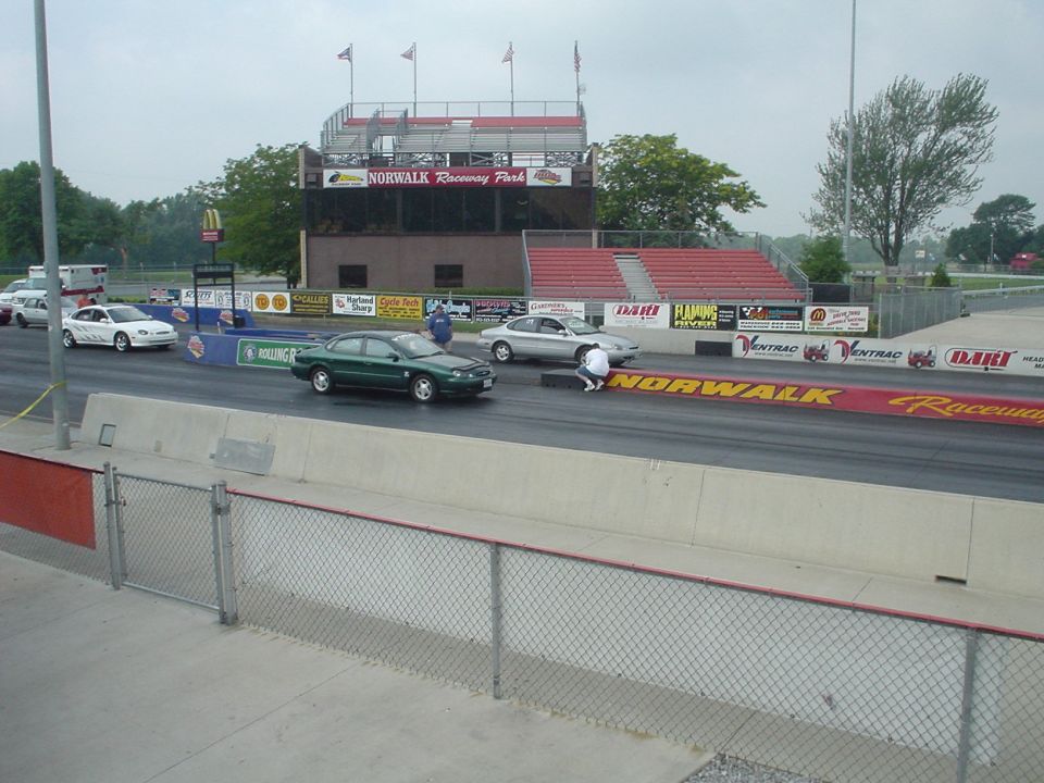 Dark green Ford Taurus sedan staging on the drag strip at Norwalk Raceway Park