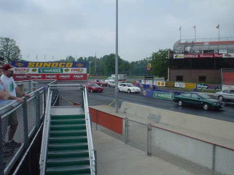 1999 Ford Taurus - Cars race down the drag strip at Norwalk Raceway Park under a cloudy sky.