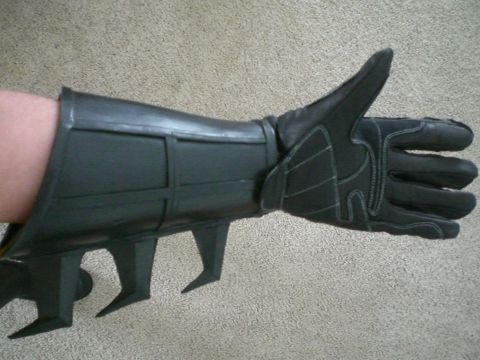 1995 Ford Probe - A black Batman glove with a gauntlet and spikes is shown with the thumb extended upwards.