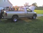 2002 Dodge 1500 - A silver 2002 Dodge 1500 pickup truck is seen with its hood open, parked outdoors on a grassy area.