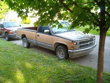 1988 Chevrolet C/K Pickup - A tan 1988 Chevrolet C/K Pickup truck is parked on the street next to a red SUV.
