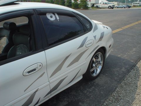 1999 Ford Taurus - This sedan features a custom tribal graphic design along its side panels and shiny chrome wheels.