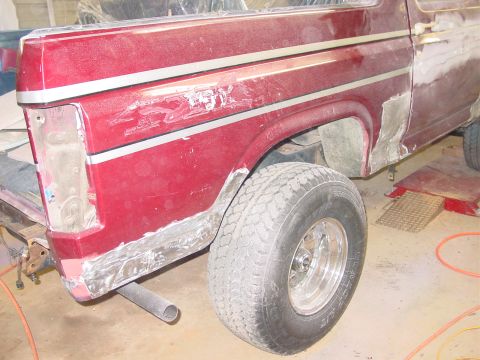 1984 Ford Bronco - This red SUV is in the process of body repair, with visible chrome trim and areas of exposed metal.