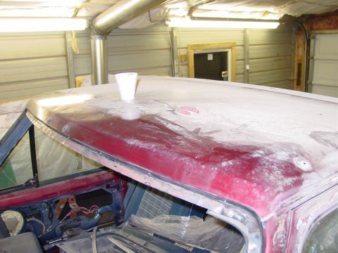 1984 Ford Bronco - Car roof undergoing bodywork, with a white cup placed on top.