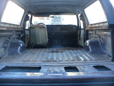 1979 Ford Bronco - The interior of an older SUV is shown, with a focus on the empty cargo space and the dashboard area.