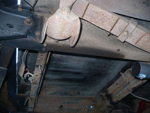 1979 Ford Bronco - The underside of a vehicle shows rusted components and a visible exhaust pipe.