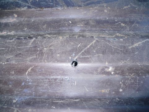 1979 Ford Bronco - Close-up of a worn interior panel, showing horizontal ridges and a single hole.