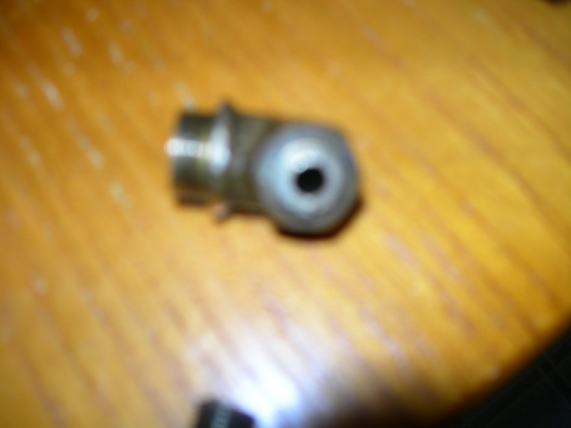 Metal fitting with a hole, on a wooden surface