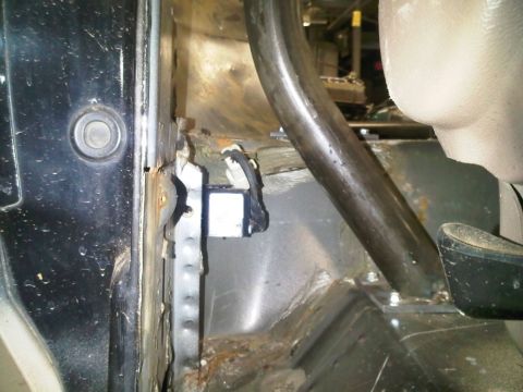 1996 Ford Bronco - Close-up of the interior showing a roll cage structure and the door jamb area, with signs of rust and wear.