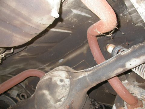 1968 Mercury Cougar - Underside view of a car's differential and exhaust system, showing rusted pipes and suspension components.
