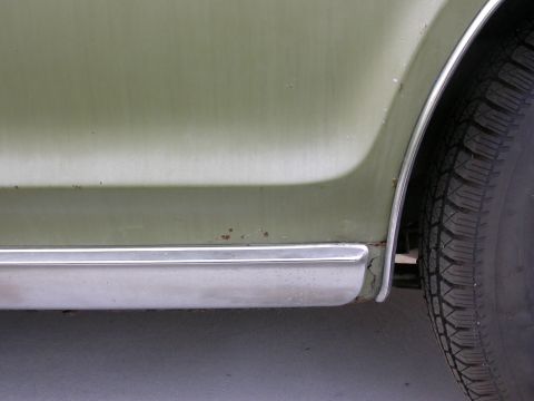1968 Mercury Cougar - Detail of a green 1968 Mercury Cougar's rear fender and tire, with visible rust and chrome trim.