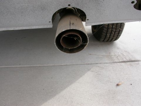 1968 Mercury Cougar - Close-up view of a vehicle's exhaust pipe and rear tire.