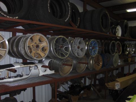 1979 Chevrolet Camaro - A storage area displays stacks of tires and an assortment of car wheels on metal shelves.