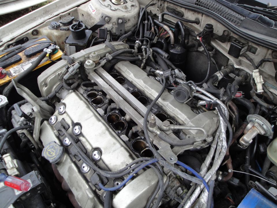 Engine bay with intake manifold removed, showing cylinders and wiring