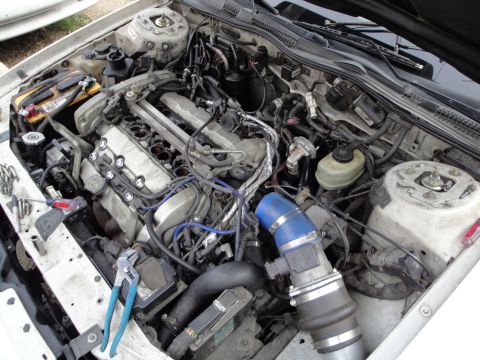 1993 Ford Taurus - The engine bay of a 1993 Ford Taurus appears to be undergoing maintenance or repair.
