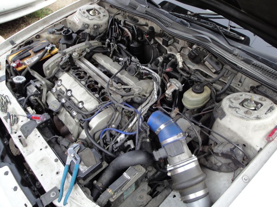 1993 Ford Taurus engine bay with parts removed, showing engine components and tools