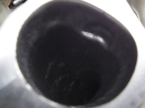 1993 Ford Taurus - The interior of an exhaust pipe shows a dark, reflective surface with some smudges and light reflections.