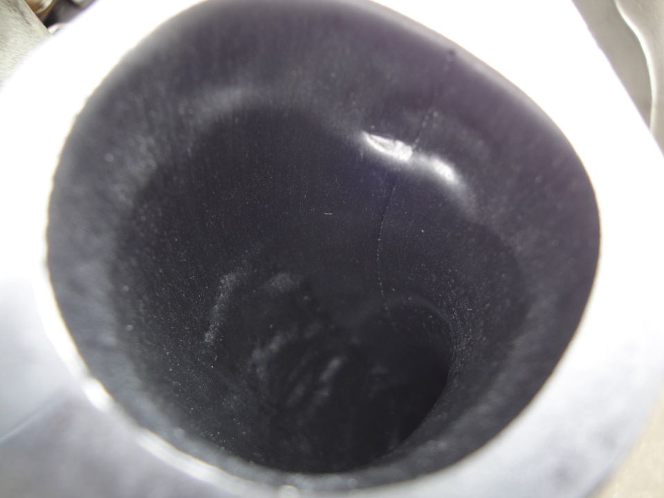 Dark automotive part interior with visible wear and dust