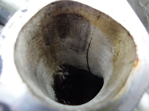 1993 Ford Taurus - Close-up view inside a metal pipe shows significant wear, dark residue, and a visible crack.