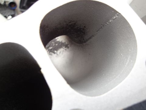 1993 Ford Taurus - A detailed view of an engine's intake manifold port, showing internal surfaces and a weld line.