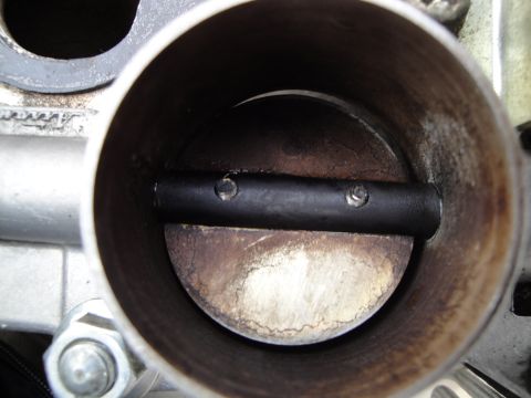 1993 Ford Taurus - Close-up view of a dirty throttle body, showing the butterfly valve and internal surfaces.