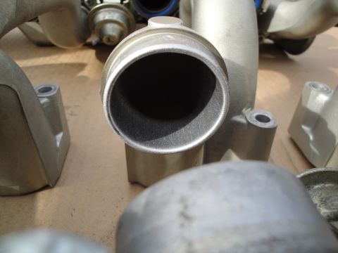 1993 Ford Taurus - Several metal engine intake manifold parts are shown in a close-up view.