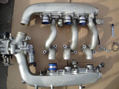 1993 Ford Taurus - A disassembled Ford DOHC 4 valve intake manifold is laid out on a cardboard surface.