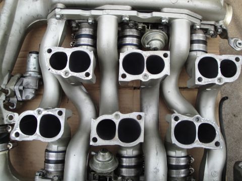 1993 Ford Taurus - Close-up view of a silver intake manifold, likely from a V6 engine, showing its complex tubing and port design.