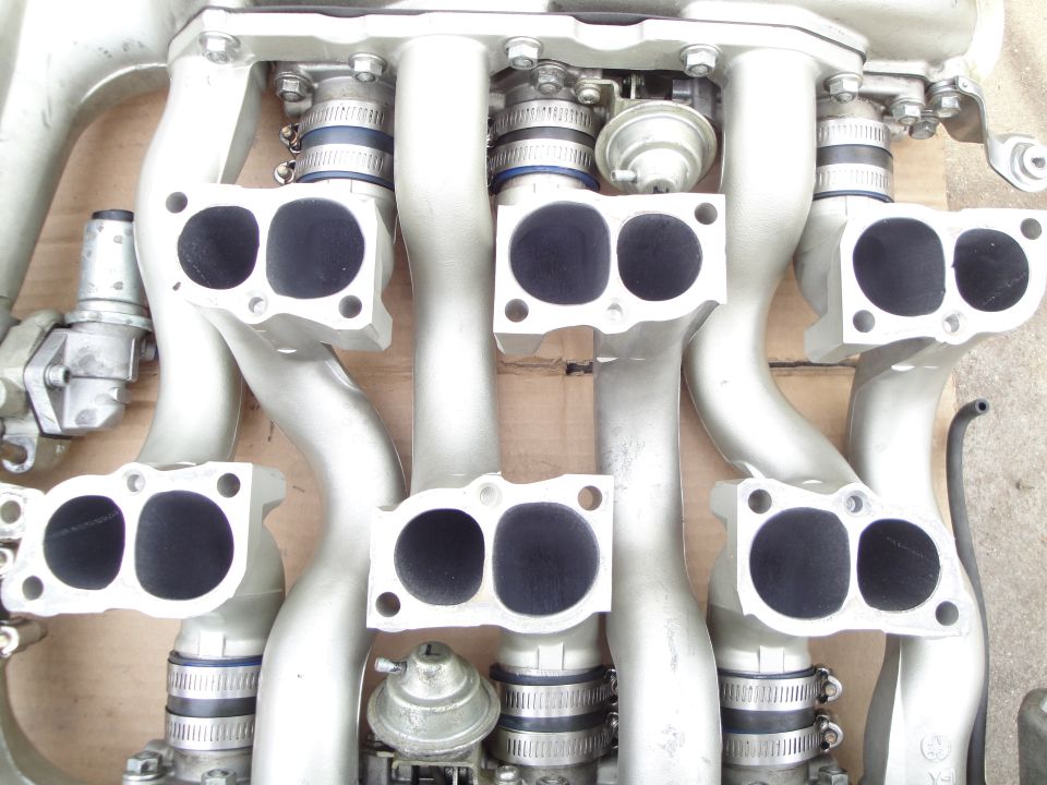 Close-up of a silver aluminum intake manifold with six ports