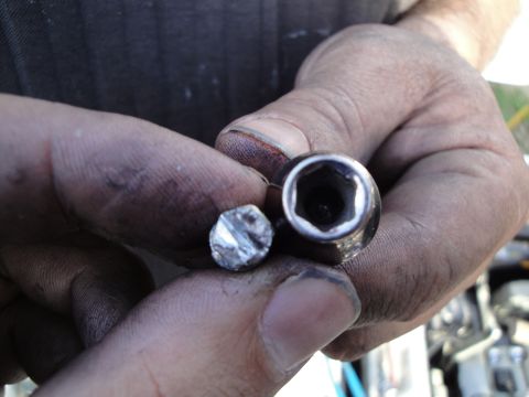 1993 Ford Taurus - A close-up shows a stripped bolt next to a socket, likely from a vehicle repair.
