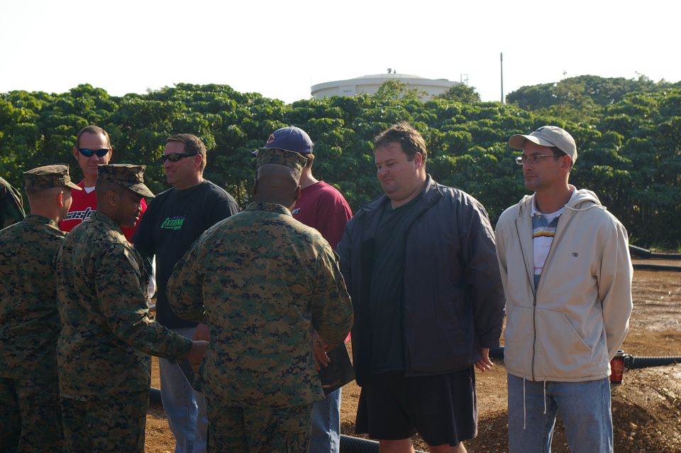 Group of men in military uniforms and civilian clothes standing outdoors