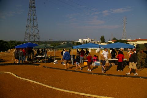 1986 Ford Bronco - An outdoor gathering takes place under tents with a large tower visible against the sky.