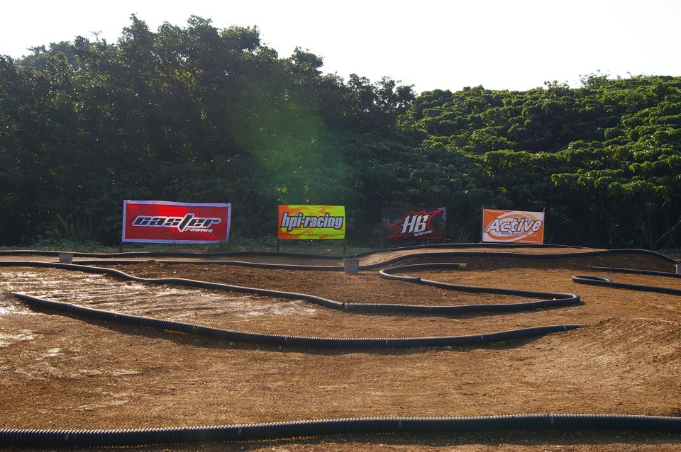 Dirt track for remote control cars with sponsor banners for HPI Racing, HB, and Active