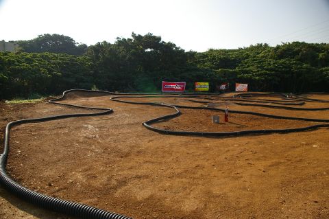 1986 Ford Bronco - An outdoor track designed for remote control cars features several turns and jumps, with sponsor banners visible.