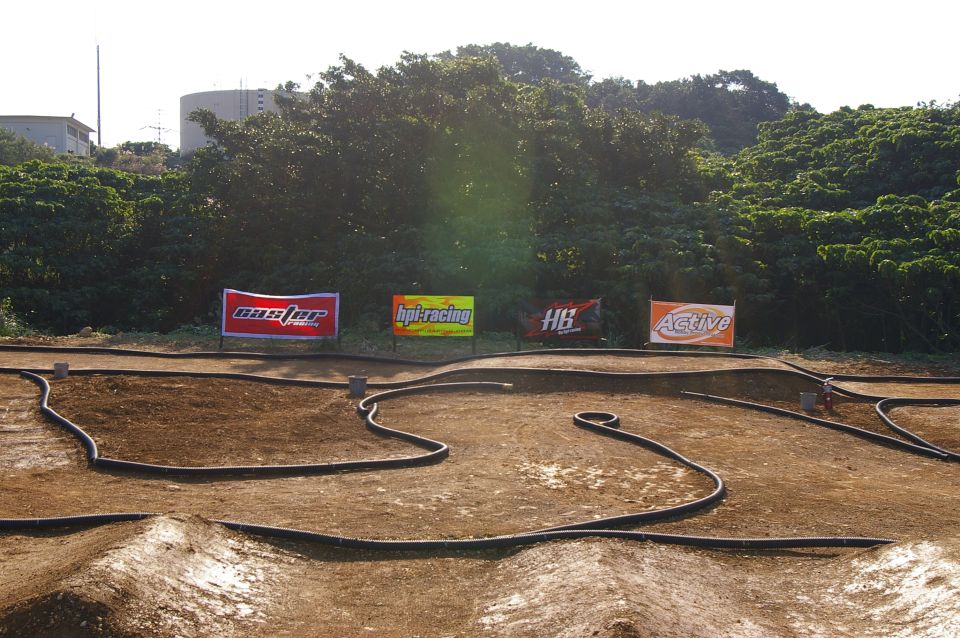 RC car race track with sponsor banners for Master, HPI Racing, HB, and Active