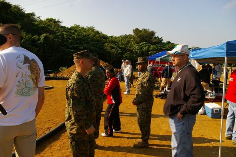 1986 Ford Bronco - Outdoor gathering with military personnel and civilians under tents on a sunny day.