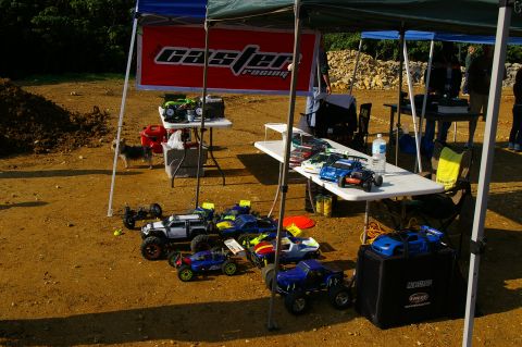 1986 Ford Bronco - RC cars are set up for display or racing under a tent with a racing banner in the background.