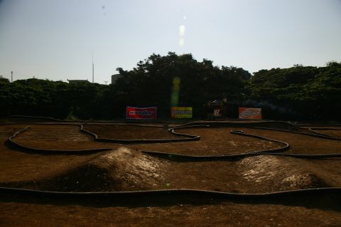 1986 Ford Bronco - An outdoor remote control car track is set up with several advertising banners visible in the background.