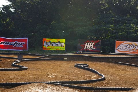1986 Ford Bronco - An outdoor RC car track features banners from various hobby brands in the background.