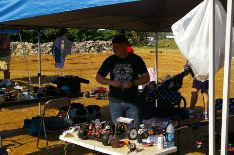 1986 Ford Bronco - RC car enthusiasts preparing their vehicles under a canopy at an outdoor event.