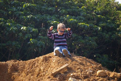 1986 Ford Bronco - A young boy enjoys himself while sitting atop a pile of dirt outdoors.