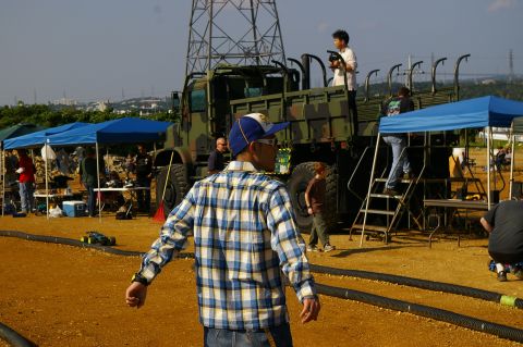 1986 Ford Bronco - A military truck is parked at an outdoor event with several people gathered around tents and equipment.
