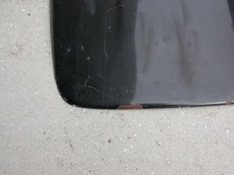 1968 Mercury Cougar - A close-up view of a black car part, showing chipped paint and scratches against a concrete background. The Supermotors.net logo is visible…