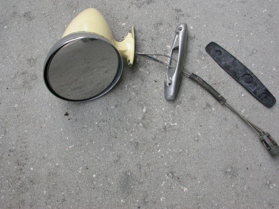 Car side mirror with mounting bracket and gasket. The mirror housing is cream colored