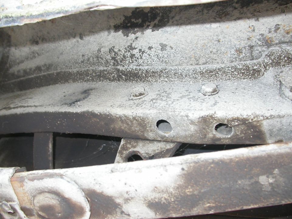 Close-up of rusty metal frame and suspension parts of a vehicle