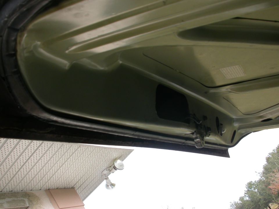 underside of a car hood, showing latch mechanism and some structural ribs