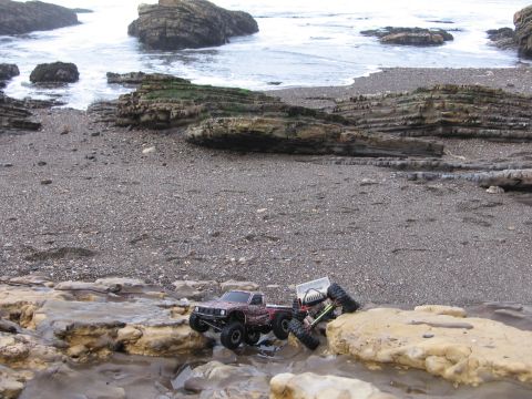 1993 Toyota 4Runner - RC trucks navigate a rocky beach with the ocean in the background.