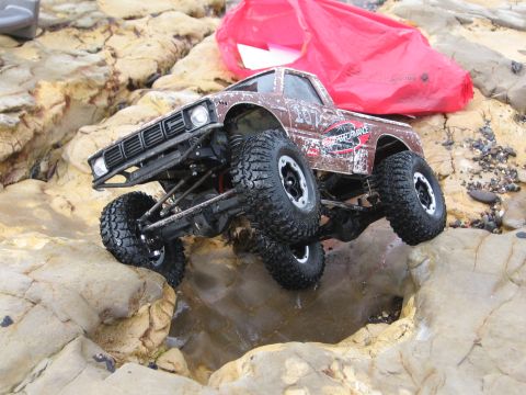 1993 Toyota 4Runner - This remote-controlled truck is shown climbing over rocks near the water.