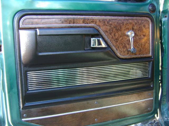 Green truck interior door panel with wood grain trim and chrome accents
